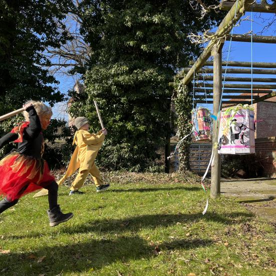Udklædte børn løber mod fastelavnstønder med hævede køller.