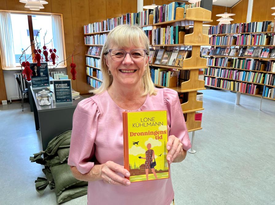 Bibliotekar Anni Bagge Jensen med bogforsiden til "Dronningens tid"